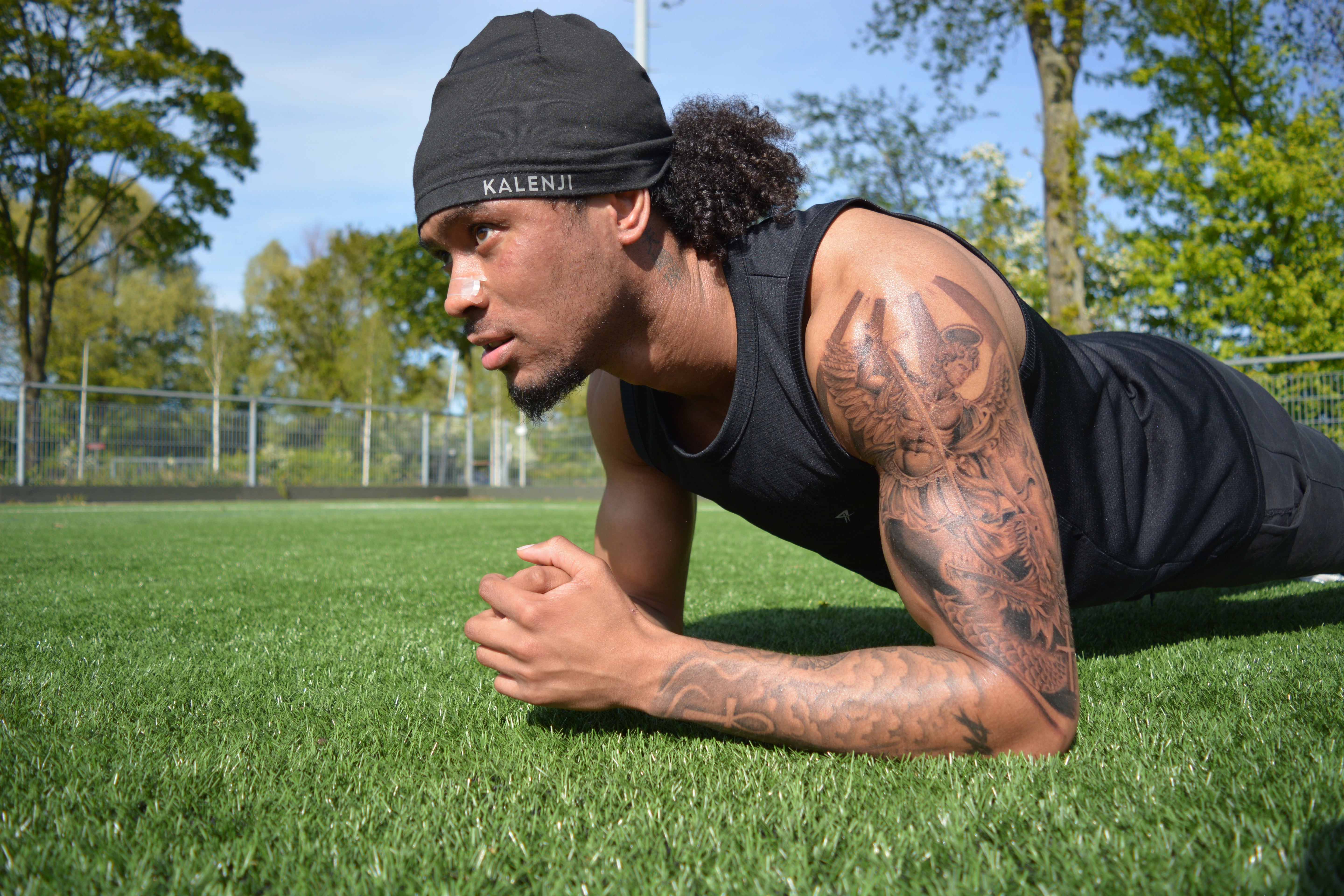 Atleet doet plank op gras met Peakform neusstrip, athlete doing plank wearing nasal strip